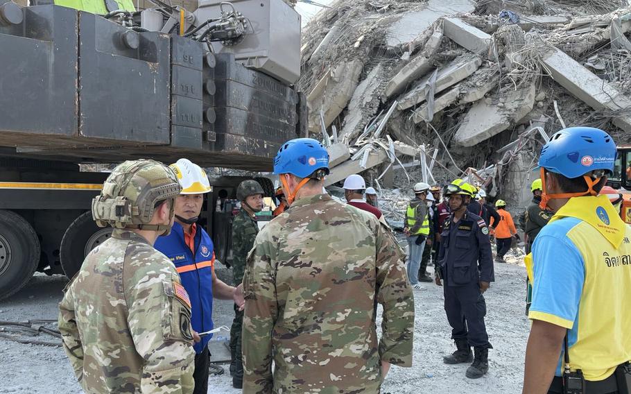 Service members survey piles of earthquake debris in Bangkok.