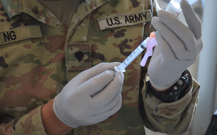 A coronavirus vaccine is prepared for injection at Fort Hood, Texas, in August 2021. 