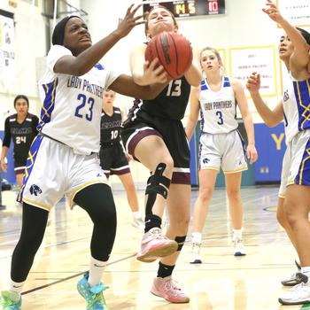 Zama's Juliet Bitor drives to the basket against Yokota's Beverly Gardner during Friday's DODEA-Japan/Kanto Plain girls basketball game. The Trojans won 30-29 in overtime.