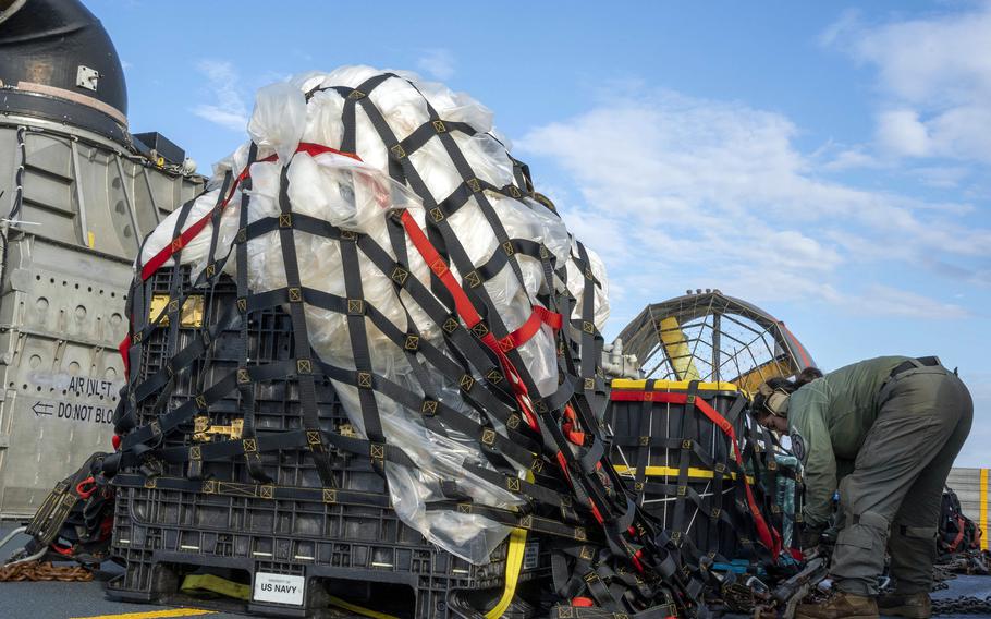 A sailor secures material recovered from a high-altitude balloon shot down off the South Carolina coast, Feb. 10, 2023. 