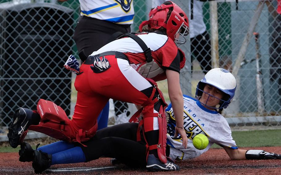 Yokota's Erica Haas steals home after getting caught leading off third base while Kinnick's Arie Evans tries to recover during Saturday's DODEA-Japan softball game. The Panthers won 14-7.
