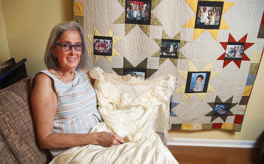 Frances Alvarez, 70, holds her mom's wedding dress, which was made from a parachute her father brought home from World War II. 