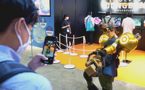 Visitors photograph an Endless Dungeon cosplayer at the Sega booth at The Tokyo Game show in Chiba, Japan, on Sept. 21, 2023.  