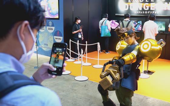 Visitors photograph an Endless Dungeon cosplayer at the Sega booth at The Tokyo Game show in Chiba, Japan, on Sept. 21, 2023.  