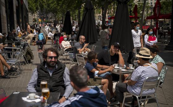 FILE - In this May 28, 2021, file photo, customers sit in a terrace bar in downtown Barcelona, Spain. Coronavirus infections, hospitalizations and deaths are plummeting across much of Europe. Vaccination rates are accelerating, and with them, the promise of summer vacations. (AP Photo/Emilio Morenatti, File)