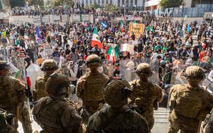 National Guard troops stand by during protests in Los Angeles. Protesters wave Mexican as well as U.S. flags.
