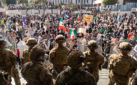 National Guard troops stand by during protests in Los Angeles. Protesters wave Mexican as well as U.S. flags.