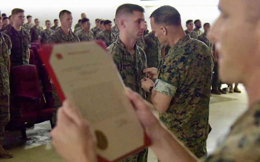 Marine Brig. Gen. Brian Wolford pins the Navy and Marine Corps Medal onto 1st Lt. Steven Ladine at Camp Hansen, Okinawa, Tuesday, June 7, 2022.
