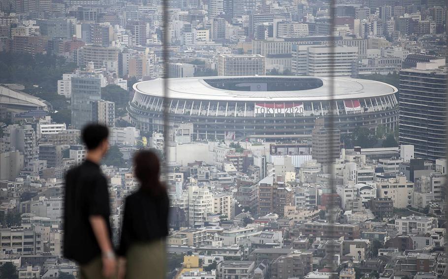 People check out Olympic Stadium from an observation deck in central Tokyo, Tuesday, July 13, 2021. 