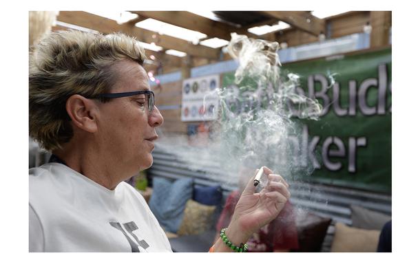 Tammy Long, a 26-year Navy veteran and co-owner of BattleBuds, smokes a hemp product on March 13 in Tampa. “Some of us don’t want to get high — we want to get better. And we don’t want to go back on pills,” she said.