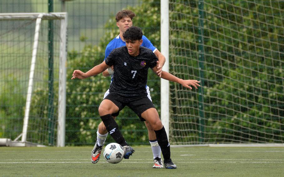 Bahrain’s Cesar Lopez shields the ball from Rota defender Zeppelin Hasselbring as he looks to pass in a Division II game at the DODEA-Europe soccer finals at Reichenbach-Steegen, Germany, May 21, 2024. Bahrain won 5-0.
