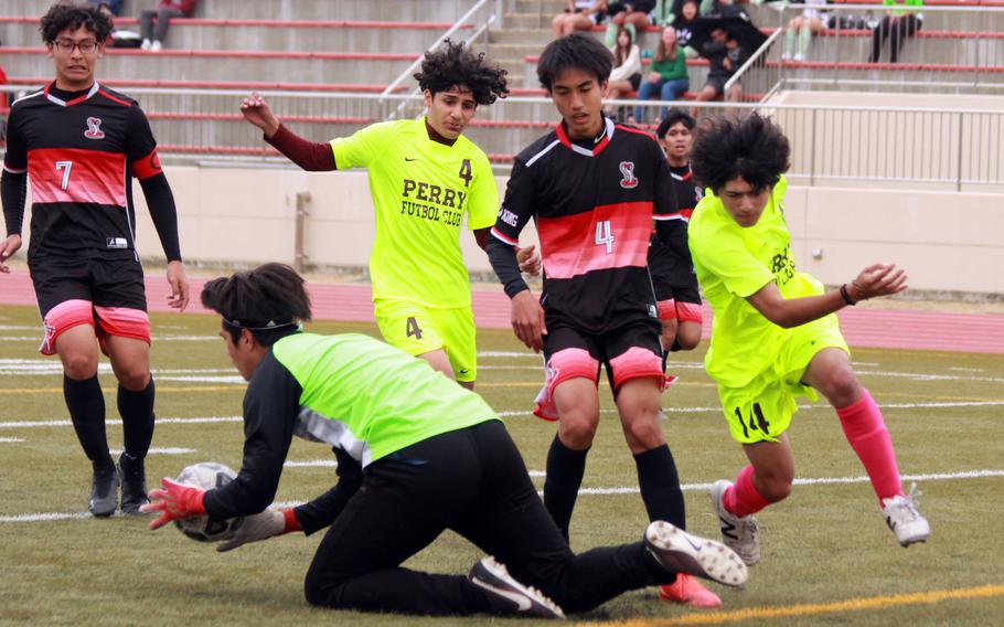 E.J. King goalkeeper Kent Monto dives onto a loose ball against Matthew C. Perry during Friday's DODEA-Japan boys socceer match. The host Samurai won 1-0.