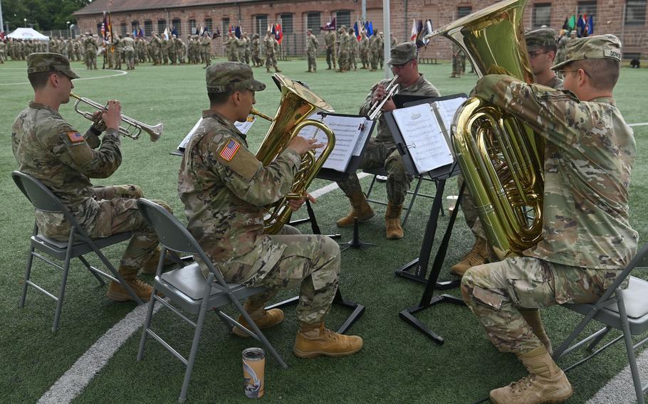 Soldiers sit and play instruments.