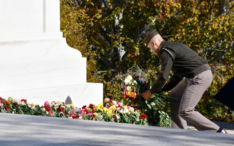 A soldier arranges flowers at the base of the Tomb of the Unknown Soldier on Wednesday, Nov. 10, 2021, during a ceremony to commemorate the tomb’s 100th anniversary. After Veterans Day, the flowers will be distributed to graves throughout Arlington National Cemetery.