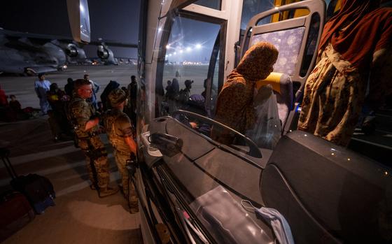 Airmen assist Afghanistan evacuees onto a shuttle, Aug. 23, 2021, at Al Udeid Air Base, Qatar. The Special Immigrant Visa program, which resettles interpreters who worked with U.S. forces in Afghanistan, may be coming to an end after lawmakers stripped provisions for its extension from the national defense bill.