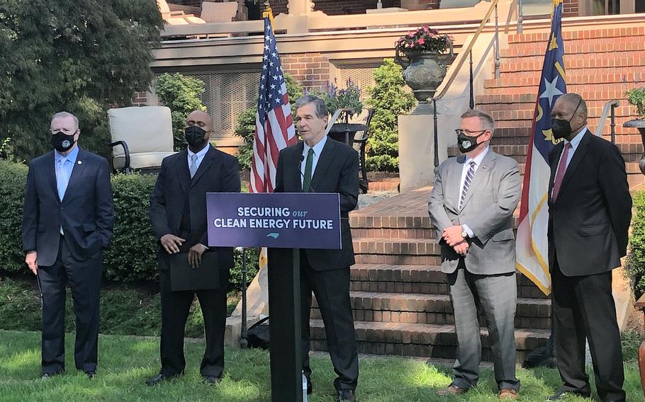 North Carolina Gov. Roy Cooper, center, speaks before he signs into law a major energy bill, listened to, from left to right, by Senate leader Phil Berger, R-Rockingham; House Minority Leader Robert Reives, D-Chatham; House Speaker Tim Moore, R-Cleveland; and Senate Minority Leader Dan Blue, D-Wake, during an Executive Mansion ceremony in Raleigh, N.C. Wednesday, Oct. 13, 2021. 