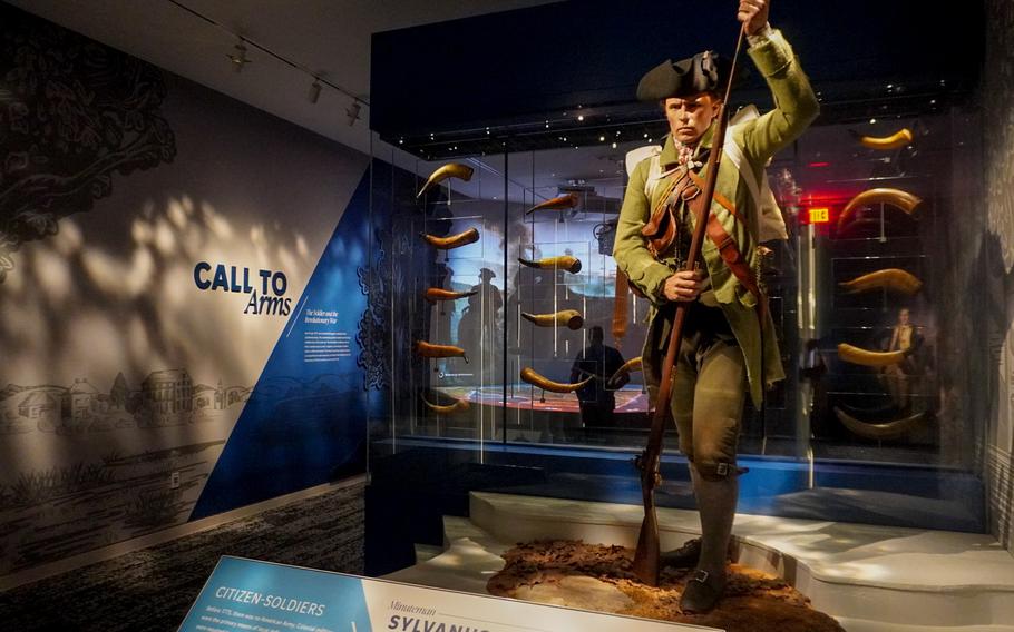 A revolutionary war cast figure stands at the entrance of an exhibit