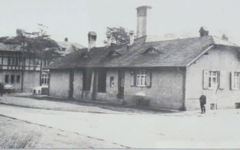 A black and white photo shows a former German military supply building with a dining facility