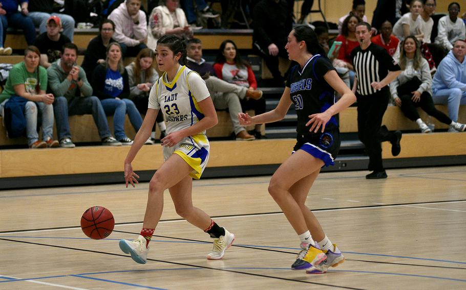Sigonella junior Ryleigh Denton drives to the bucket on the fast break as Brussels sophomore Haley Mitchell chases during pool-play action of the DODEA European basketball championships on Feb. 14, 2024, at the Wiesbaden Sports and Fitness Center on Clay Kaserne in Wiesbaden, Germany.