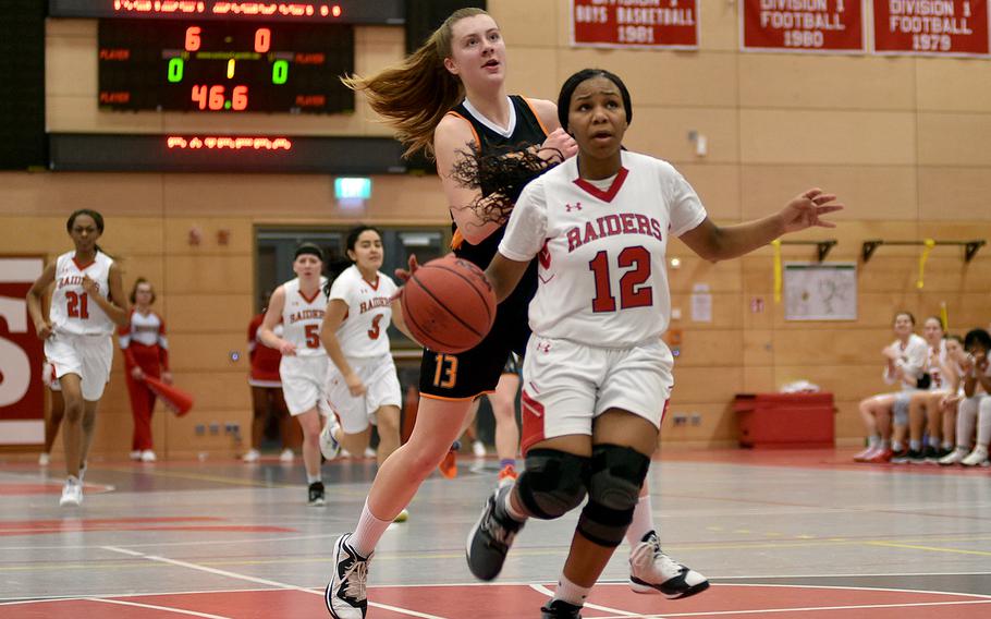 Kaiserslautern's Se'maiya Farrow heads for a layup as Spangdahlem's Isabel Bodily tries to get back during Friday evening's game at Kaiserslautern High School in Kaiserslautern, Germany.