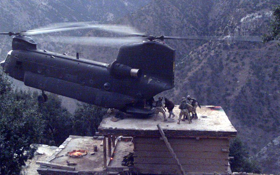 A CH-47D Chinook flown by Chief Warrant Officer 3 Larry Murphy rests its rear wheels on a house during Operation Mountain Resolve in Nuristan Province, Nov. 10, 2003, as they re-supply troops. The rest of the Chinook crew was Chief Warrant Officer 4 Paul Barnes, Sgt. 1st Class Jim Duggan, Sgt. Brian Kilburn and Spc. Margaret Haydeck.   Many of the areas where the Chinooks fly don’t have traditional helicopter landing pads. 