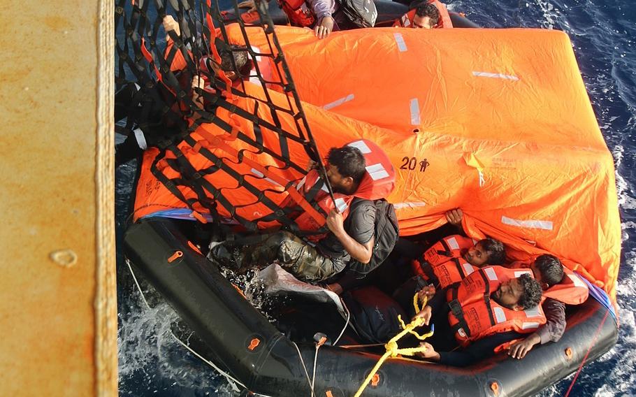 Crew members of the commercial ship Falcon Line climb aboard the Military Sealift Command fleet replenishment oiler USNS Patuxent during rescue operations in the Gulf of Aden, June 8, 2021. 