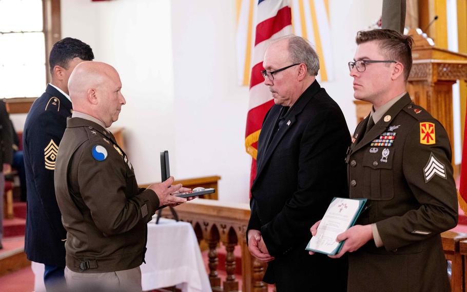 Samulski holds the medal that he will present to the family.