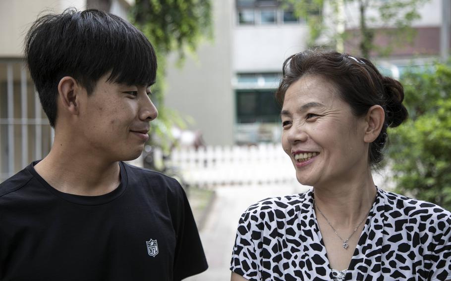 Kim Kang-woo, left, and his mother, Im Su-ryuh, near her apartment in Seoul on July 12, 2022. Kim, a North Korean defector who escaped their homeland first, went back in to North Korea to try to bring his mom to the South. 