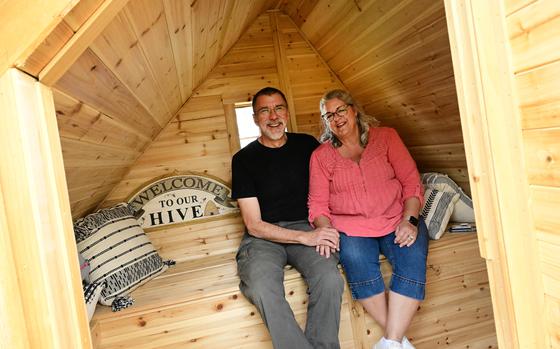 Charlie Peterson and his wife, Carolyn, owners of Capella Ranch in Lafayette, Colo., sit together inside one of their two new “Bee Huts” on May 2. They keep four beehives inside the two handmade huts, where visitors can relax just inches from the bees without getting stung. 