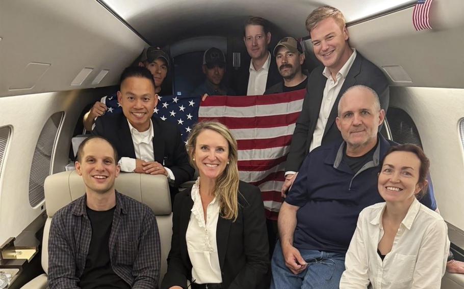 A group of people smile in an airplane.