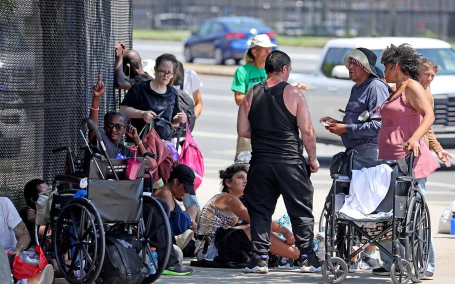 People gather on a sidewalk.