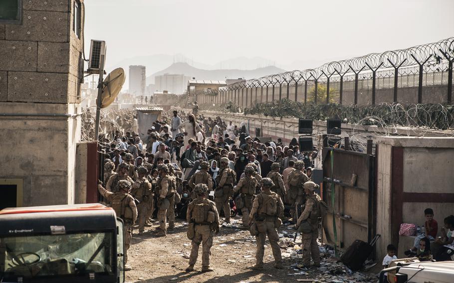 In this Aug. 21, 2021, photo provided by the Marines, Marines with the Special Purpose Marine Air-Ground Task Force — Crisis Response — Central Command provide assistance at an evacuation control checkpoint during an evacuation at Hamid Karzai International Airport in Kabul, Afghanistan. 