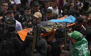 Palestinian mourners, some armed, carry the body of Amjad al-Fayyed, 17, during his funeral in the West Bank refugee camp of Jenin, Saturday, May 21, 2022. Israeli troops shot and killed al-Fayyed as fighting erupted when soldiers entered a volatile town in the occupied West Bank early Saturday, the Palestinian health ministry and local media said. (AP Photo/Majdi Mohammed)
