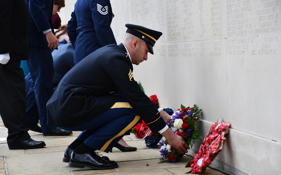 A U.S. service member lays down a wreath at the end of the Memorial Day ceremony at the Cambridge American Cemetery on Monday, May 30, 2022.