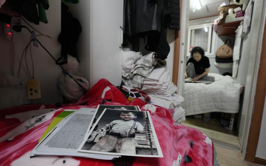 Photos of Choi Young-ja’s son, Paik Sang-yeol, who went missing in 1975, sit on a bed in her motel room in Seoul, South Korea, Tuesday, March 5, 2024. 