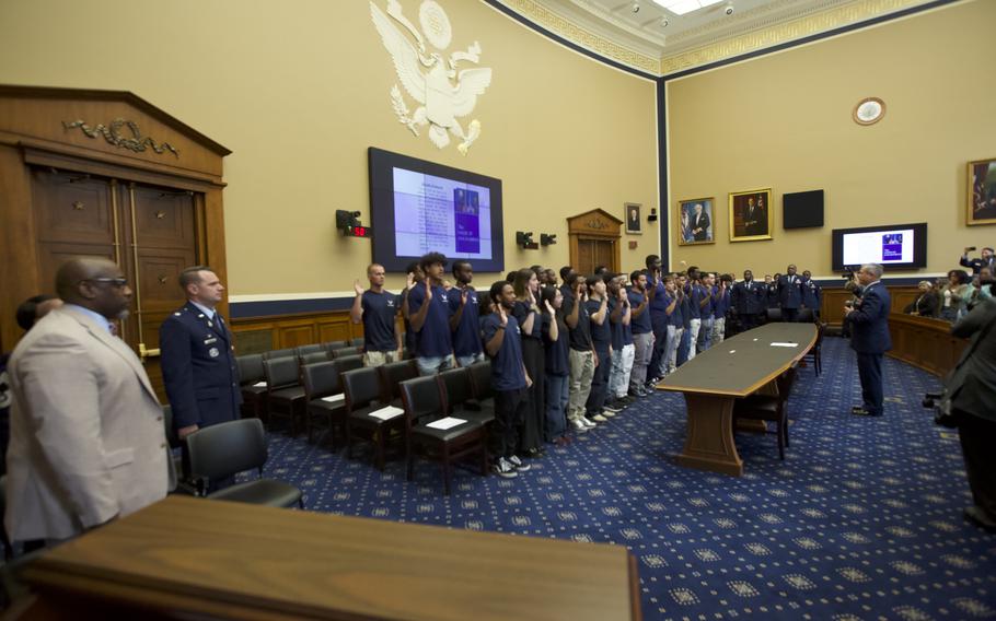 Future airmen raise their hands as they are sworn in.