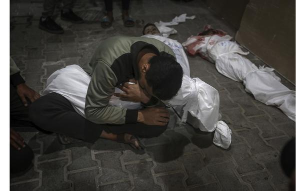 A Palestinian youth mourns his relative killed in the Israeli bombardment of the Gaza Strip, at the morgue of the Kuwaiti Hospital in Rafah refugee camp, southern Gaza Strip, early Saturday, April 20, 2024. (AP Photo/Ismael Abu Dayyah)