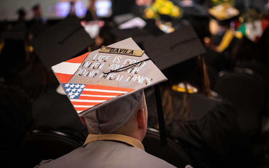 A UMGC student watches other graduates receive their diplomas at a ceremony on Ramstein Air Base, Germany, Saturday, April 29, 2023.