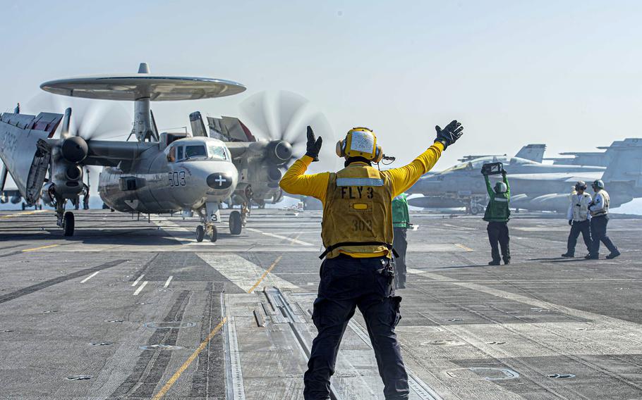 Petty Officer 2nd Class Brandon Frayde guides an E-2C Hawkeye to launch aboard the aircraft carrier USS Dwight D. Eisenhower in the Red Sea in November 2023.
