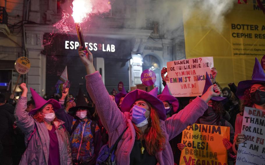 A woman holds up a flare as she marches with others during a protest marking the International Day for the Elimination of Violence against Women in Istanbul, Turkey, Thursday, Nov. 25, 2021. Police on Thursday fired tear gas to break up a protest by women in Istanbul who were marching to press for Turkey’s return to a landmark treaty that aims to protect women from violence.