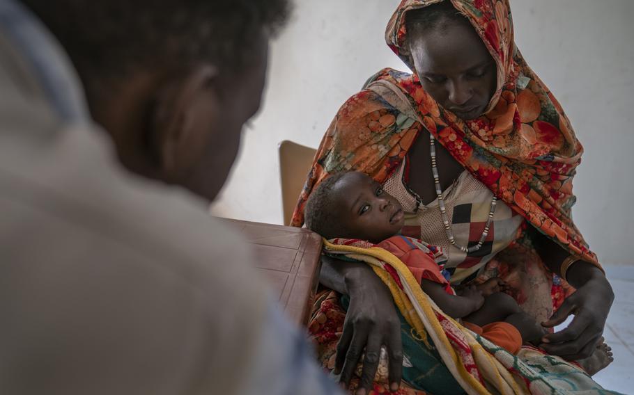 A doctor at the mobile clinic examines 2-year-old Abdal Majib Abdullah, the youngest of Gisma Al Kher Hassan’s four children. Ten days before, Al Kher Hassan, 26, had returned to Sirba from Chad, where she had been a refugee for months. She is staying in an old primary school with hundreds of others.