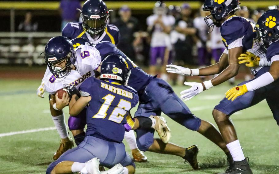 George Washington receiver Jake Cruz is wrapped up by Guam High's DeShawn Baird as Panther teammates Elijay Ferrell-Ayers and Braden Flinn move in to help.