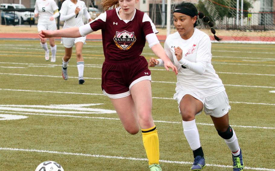 E.J. King's Miu Best and Matthew C. Perry's McKenzie Mitchell chase the ball during Saturday's DODEA-Japan girls soccer match. The Cobras and Samurai played to a 2-2 draw.