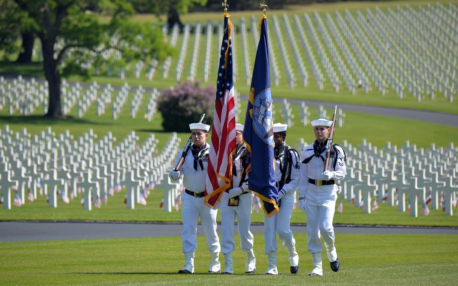 A U.S. Navy color guard present the colors at the Memorial Day ceremony at Lorraine American Cemetery in St. Avold, France, May 28, 2023. Behind the sailors are some of the cemetery’s 10,481 graves. 