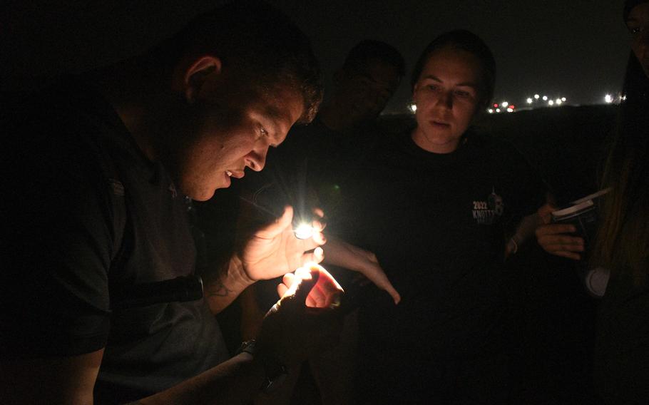 Army Spc. Joseph Neitz, left, examines an ant while hunting for scorpions, camel spiders and other potentially dangerous critters at Ali Al Salem Air Base in Kuwait on Nov. 28, 2022. 