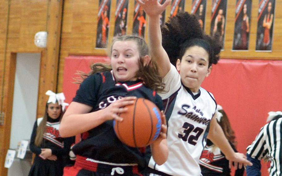 E.J. Kikng's Madylyn O'Neill looks for help against Matthew C. Perry's Nyla Matos during Saturday's DODEA-Japan girls basketball game. The Cobras won 51-18.