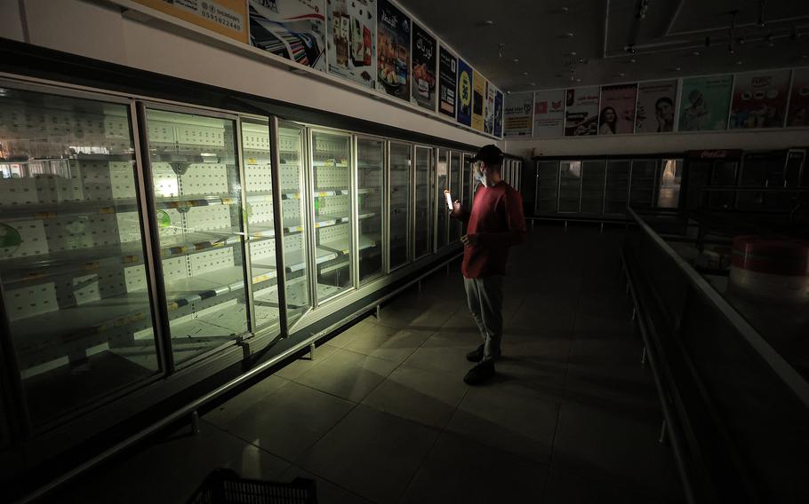 A man inspect empty shelves in a closed supermarket in Khan Younis in the southern Gaza Strip on Nov. 30.