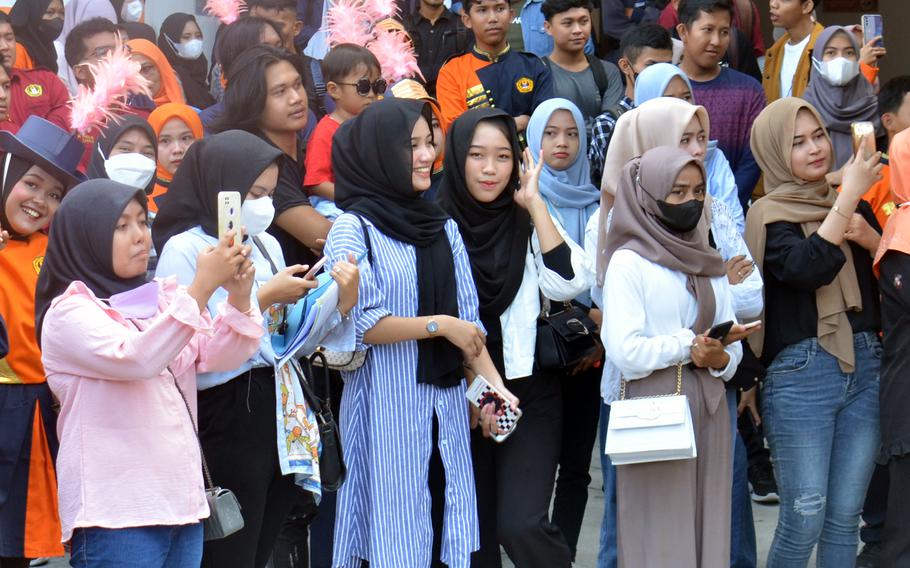 Students smile and take photos and videos as the U.S. Army's Tropic Lightning Band performs at Baturaja University in Indonesia, Thursday, Aug. 11, 2022. 