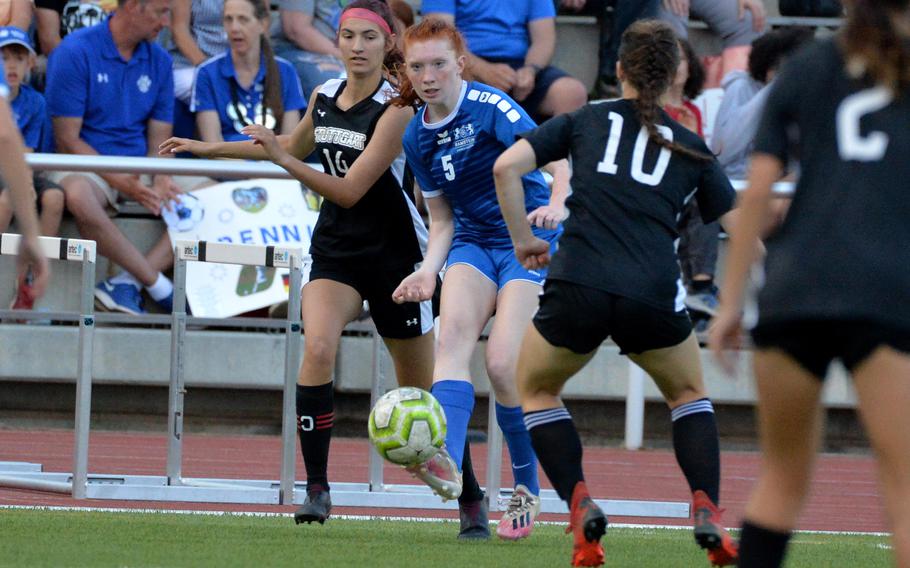 Ramstein’s Gabriella Clark centers the ball as Stuttgart’s Kendall Boudreaux, left, and Bella Henderson in the girls Division I final at the DODEA-Europe soccer championships in Kaiserslautern, Germany, May 19 2022. The game ended 1-1 and both teams were named co-champions after a lightning storm stopped the game.
