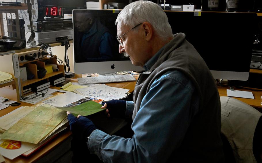 Vietnam War veteran Jim Roberts examines documents at his home in a Pittsburgh suburb in November 2021. He had been trying to find the Donut Dollies he met and photographed in Vietnam during the war. 